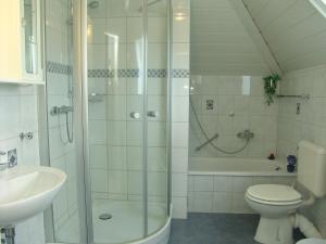 uma casa de banho com um chuveiro, um WC e um lavatório. em Norderpiep em Büsum