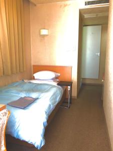 En eller flere senger på et rom på Asahi City Inn Hotel