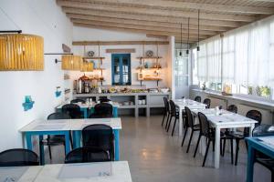 a room with tables and chairs in a restaurant at Nicolas in Órmos