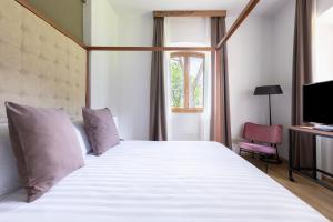 Schlafzimmer mit einem großen weißen Bett und einem Fenster in der Unterkunft Antico Borgo di Sutri in Sutri