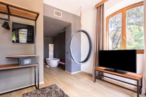 a living room with a tv and a mirror at Antico Borgo di Sutri in Sutri