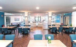 a restaurant with wooden tables and blue chairs at New Work Hotel Essen in Essen