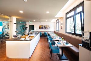 a restaurant with a long counter and blue chairs at New Work Hotel Essen in Essen