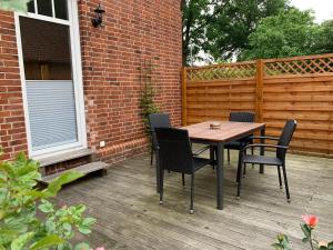 a wooden table and chairs on a patio at Ferienhaus Fegebank in Nienhagen in Nienhagen