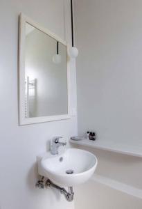 a white bathroom with a sink and a mirror at Nicolas in Órmos