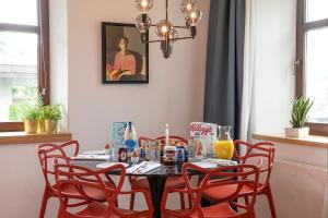 キルヒビッヒルにあるZu Hause im schönen Tirolのダイニングルームテーブル(赤い椅子、食べ物を入れたテーブル付)
