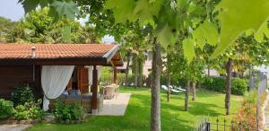 a house with a garden with a bench and trees at Residence Villalsole in San Felice del Benaco