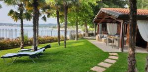 a garden with palm trees and a house at Residence Villalsole in San Felice del Benaco