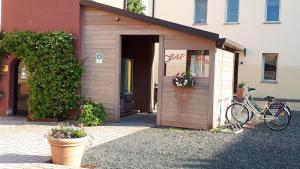ein kleiner Schuppen mit einem Fahrrad, das außerhalb eines Gebäudes geparkt ist in der Unterkunft Villa Meli Lupi - Residenze Temporanee in Parma