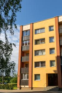 un edificio amarillo con ventanas laterales en Brand New, Family-friendly with a great location - Moon Apartment, en Ventspils