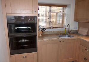 a kitchen with a stove oven and a sink at Thornton in Chipping Campden