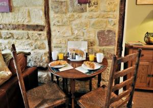 a wooden table with two plates of food on it at Thornton in Chipping Campden