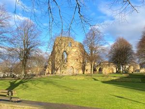 ein Gebäude in einem Park mit einem grünen Feld in der Unterkunft Orchard Club - Newton House in Knaresborough