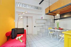 ein Wohnzimmer mit einem roten Sofa und einer Küche in der Unterkunft Welcome to Trastevere in Rom