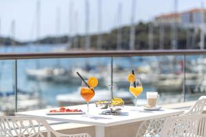 a table with two glasses of orange juice on a balcony at Ribarska Koliba Resort in Pula