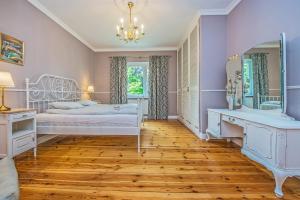 a bedroom with two beds and a mirror at Victus Apartamenty, Apartament Dębowa in Sopot