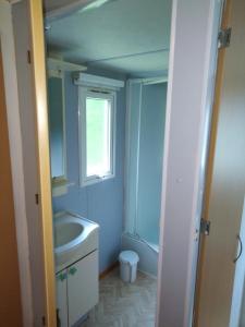 a bathroom with a sink and a toilet and a window at Camping de Marcilly sur Vienne in Marcilly-sur-Vienne