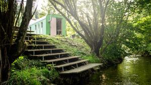 eine Treppe neben einem Fluss mit einem Gebäude in der Unterkunft Landhotel Untere Mühle in Straßberg
