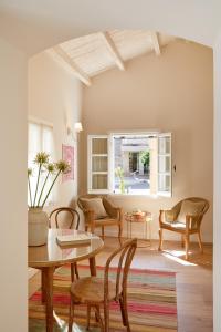 een woonkamer met een tafel en stoelen en een raam bij Old Town Luxury Suites 'Contessa' in Ágios Rókkos