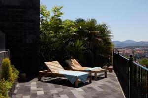 two chairs on a patio with a view of a city at Boutique Hotel Mendi Argia in San Sebastián