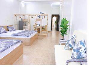 a bedroom with two beds and a table and chairs at Xoài Xanh Hostel & Villa in Vung Tau