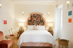 een slaapkamer met een groot wit bed met een bloemrijk hoofdeinde bij Old Town Luxury Suites 'Contessa' in Ágios Rókkos