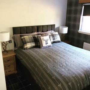 a bedroom with a bed with pillows and two lamps at The Juniperlea Inn in Pathhead