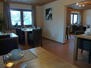 un comedor con mesas y sillas en un restaurante en Landhaus Meine Auszeit, en Bodenmais