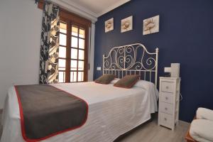 アレーナス・デ・サン・ペドロにあるHostería El Bodegón De Gredosの青い壁のベッドルーム1室(大型ベッド1台付)
