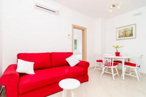sala de estar con sofá rojo y mesa en Apartments Eva, en Dubrovnik