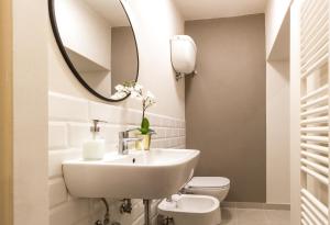 een badkamer met een wastafel, een toilet en een spiegel bij Il Cuore di Chiusi - Autentica Casa in Toscana in Chiusi
