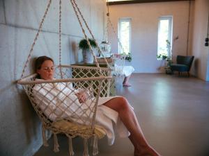 a woman sitting in a swing in a room at Hotel Landhafen in Niebüll