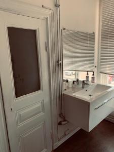 a white bathroom with a sink and a mirror at Stekhuset B&B in Kalmar