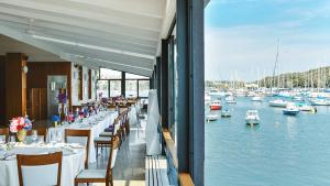 a restaurant with tables and chairs and boats in the water at Ribarska Koliba Resort in Pula