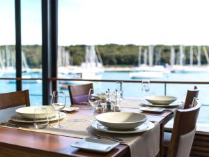 a wooden table with plates and wine glasses on it at Ribarska Koliba Resort in Pula