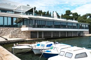 three boats are docked in the water in front of a building at Ribarska Koliba Resort in Pula