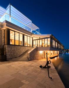 a large building with stairs and glass windows at Ribarska Koliba Resort in Pula