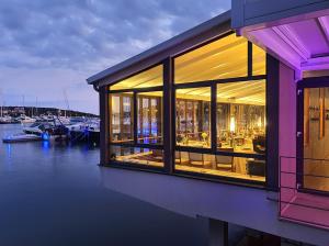 a building with windows with a boat in the water at Ribarska Koliba Resort in Pula