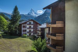 
a large building with a view of a mountain range at BaseCamp Hotel in Zermatt
