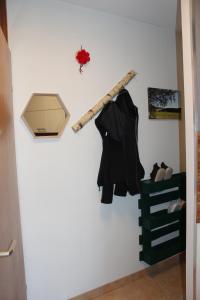 ein Holzstock hängt an einer Wand mit einem Mantel in der Unterkunft 1-Zimmer-Apartment mit großem Balkon in Schönwald