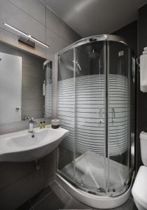 y baño con ducha acristalada y lavamanos. en Byzantio Hotel, en Ioannina