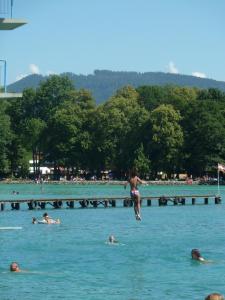un gruppo di persone che nuotano in acqua di Vintage-Ferienwohnung für 2 a Schörfling am Attersee