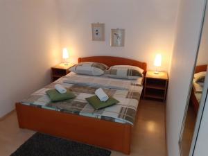 a small bedroom with two beds and two lamps at Apartment & Rooms Riva in Vodice