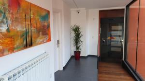 a hallway with a painting on the wall and a plant at Apartaments y Habitacions Entre Volcans in Olot