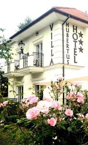 a white building with a sign on the side of it at Hotel Villa Hubertus Kutno in Kutno