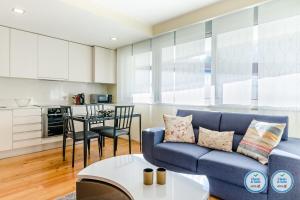 un soggiorno con un divano blu e un tavolo di RS Porto Boavista Studios a Porto