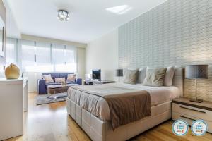 una camera da letto con un letto grande e un soggiorno di RS Porto Boavista Studios a Porto