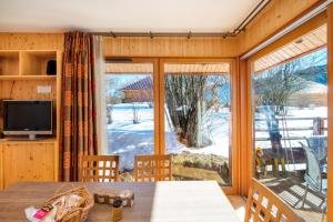 comedor con mesa y ventana grande en Loges du Jura, en Cerniébaud