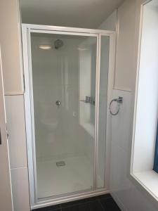 a shower with a glass door in a bathroom at Queens Arms Hotel in Longford