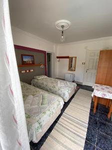 a hotel room with two beds and a table at Rose Pension in Patara